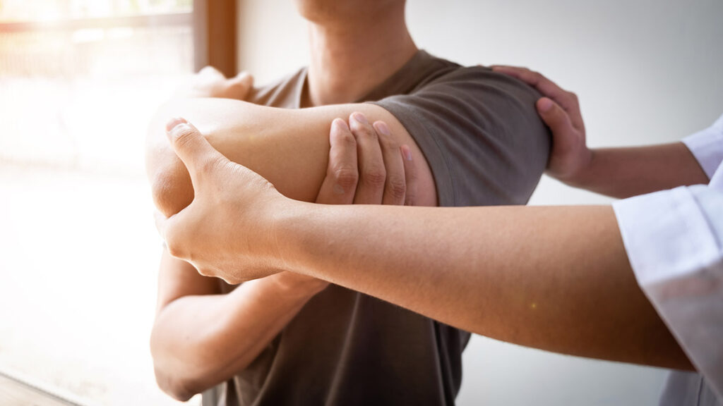 Therapist treating a male injured by rotator cuff stretching method, Physical therapy.